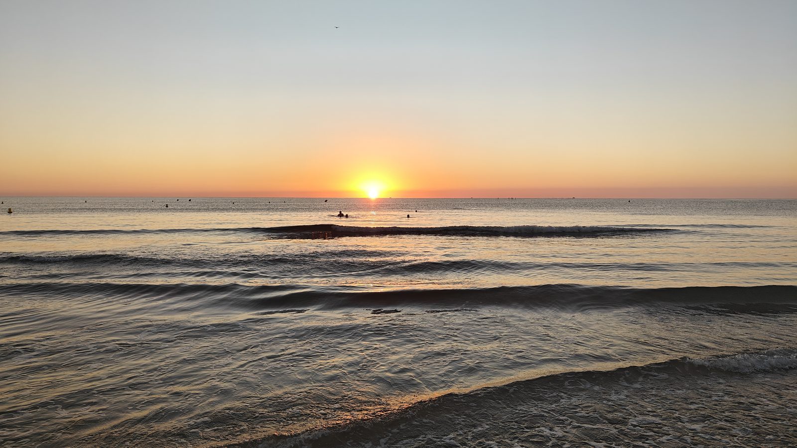 Morning sun over gentle waves at La Zenia beach