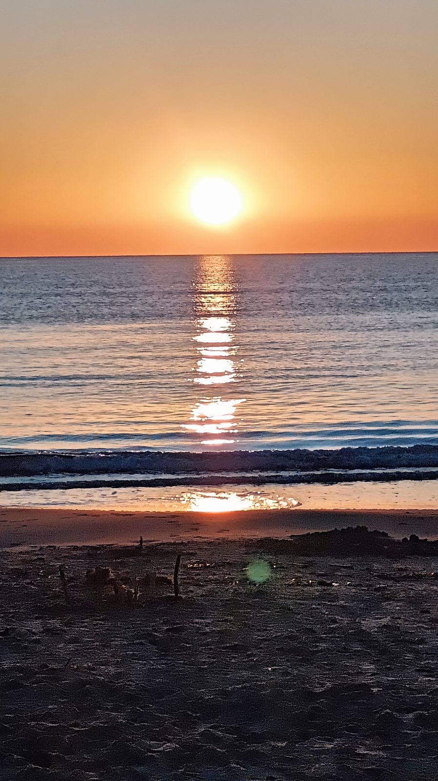 Bright sun and its reflection on the sea beyond the sand at La Zenia beach