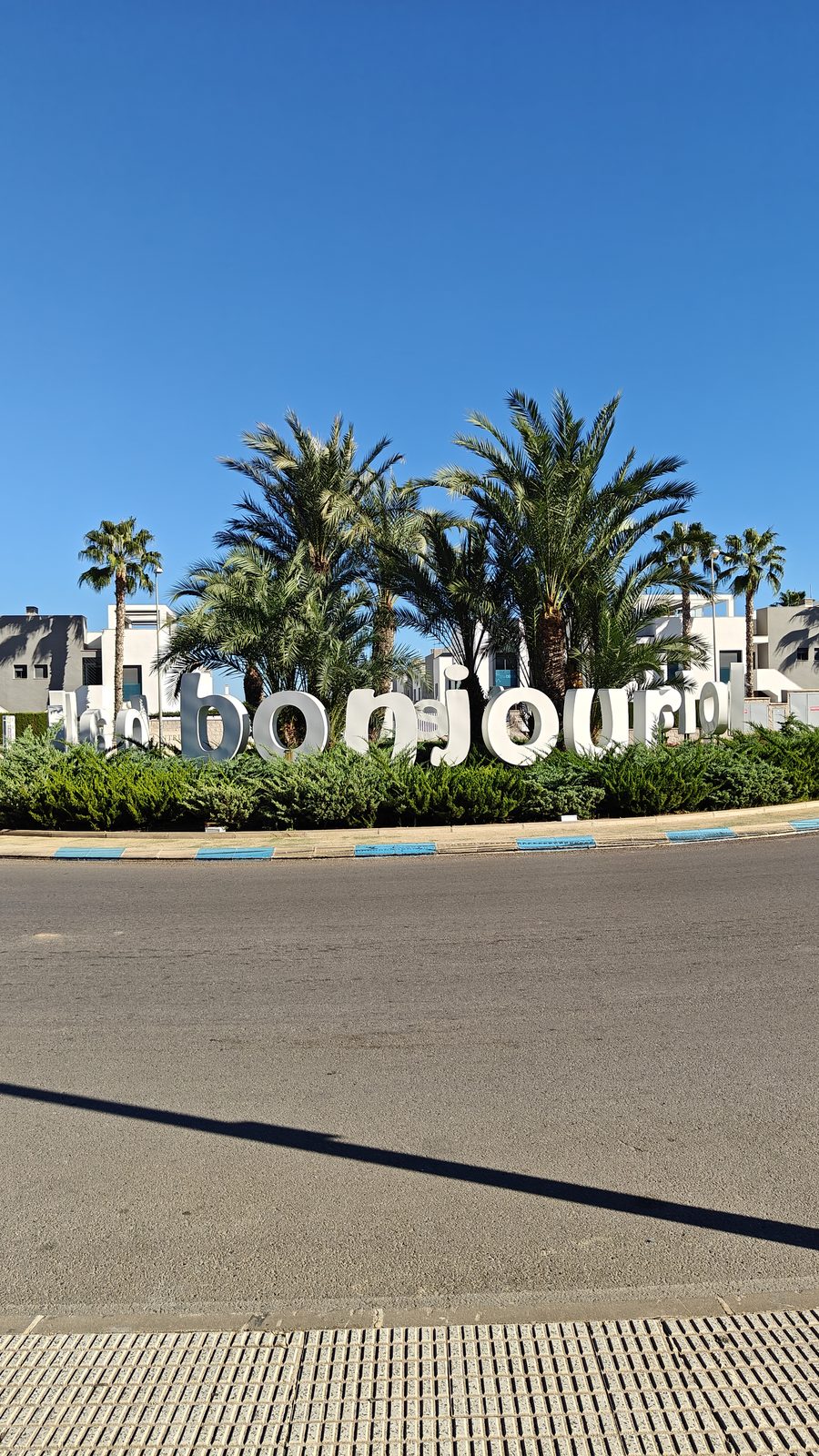 Large welcome lettering and palm trees outside Zenia Boulevard