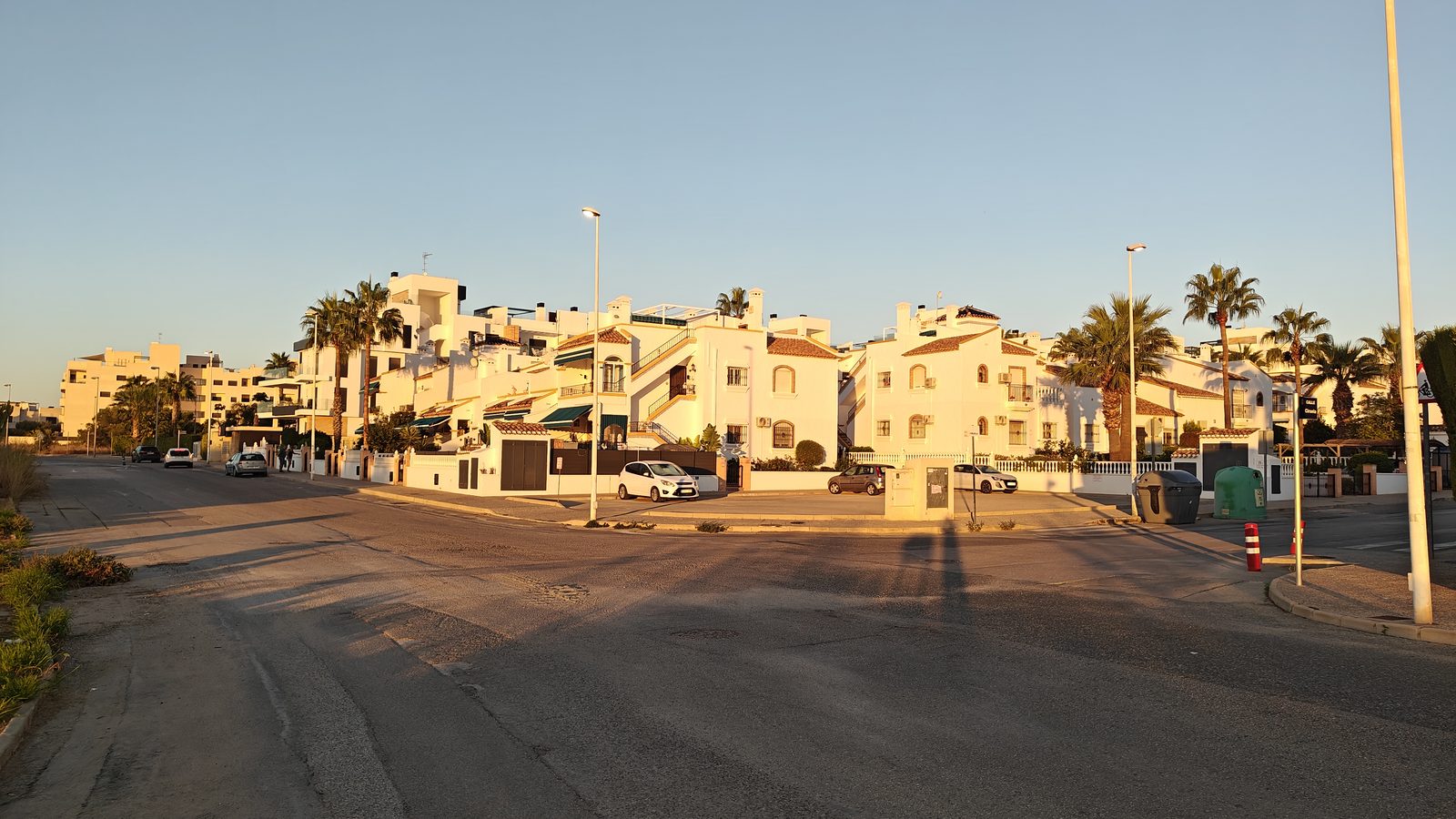 White villas along a wide avenue in Playa Flamenca in early-morning sun
